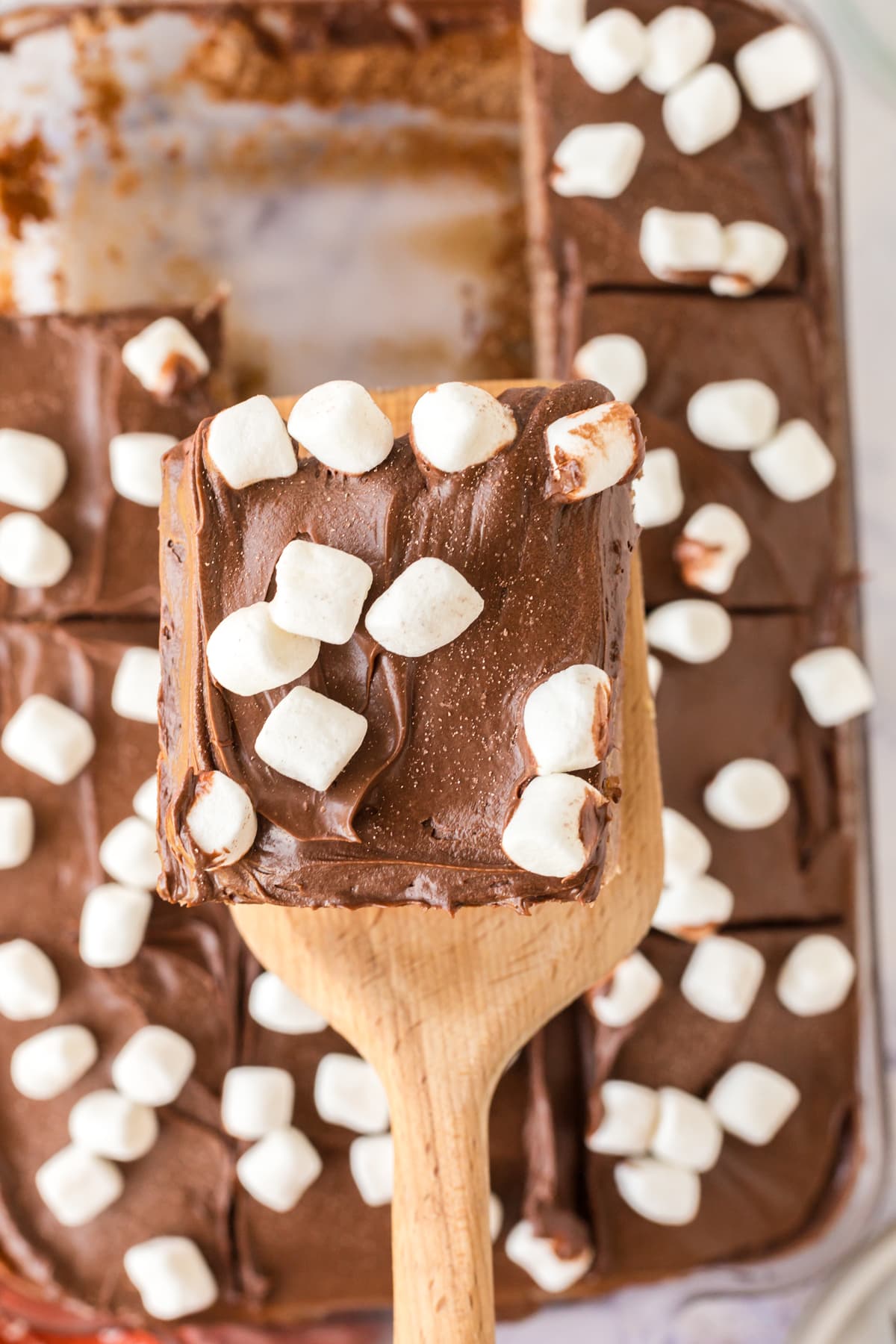 A Hot Chocolate Poke Cake square on a wooden laddle.