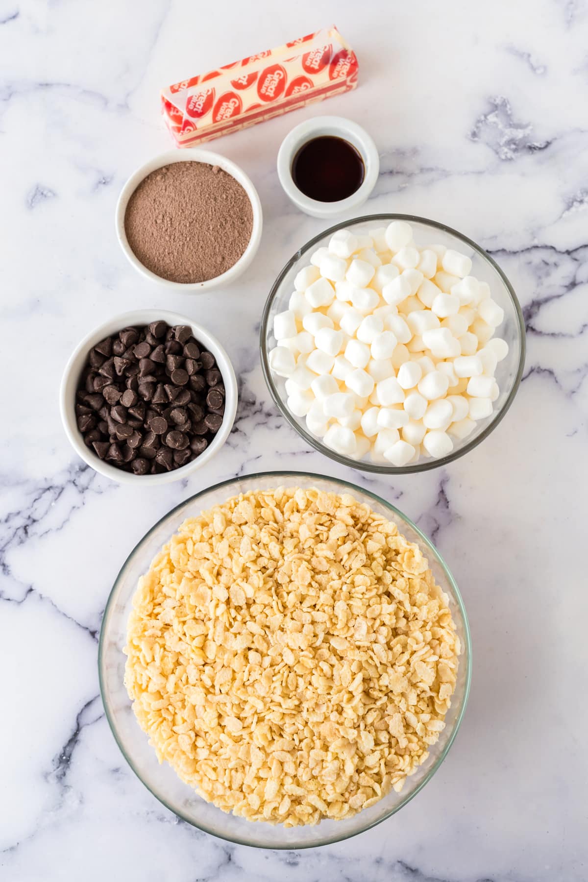 Ingredients for Hot Chocolate Rice Krispy Treats are the following: salted butter, vanilla extract, miniature marshmallows, divided, hot chocolate mix, rice Krispies cereal and semi-sweet chocolate chips