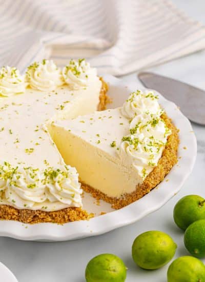 A slice of key lime pie is sitting on a white plate.