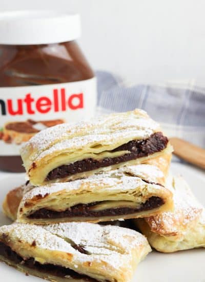 Nutella pastries on a plate with a jar of nutella.