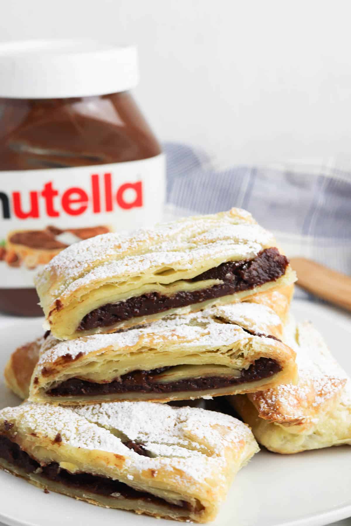 Nutella pastries on a plate with a jar of nutella.