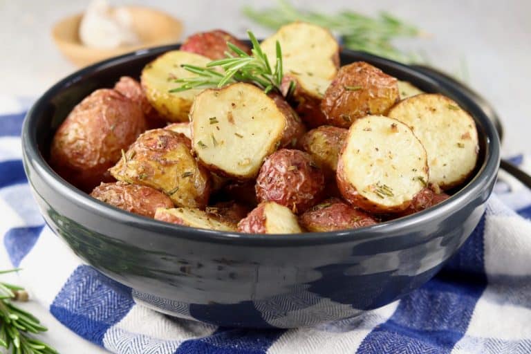 Roasted potatoes in a bowl with rosemary.
