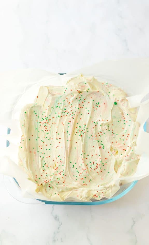 A baking dish with a layer of icing and sprinkles.