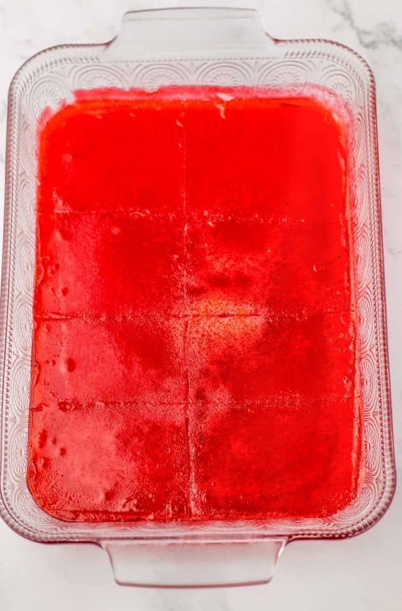 A glass baking dish filled with red jelly.