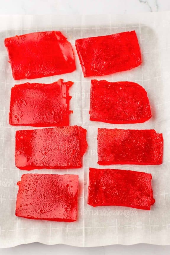 Red gelatin rectangles on a baking sheet.