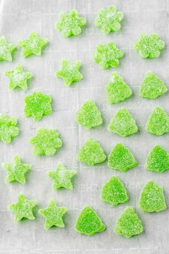 Green gummy candies on a baking sheet.
