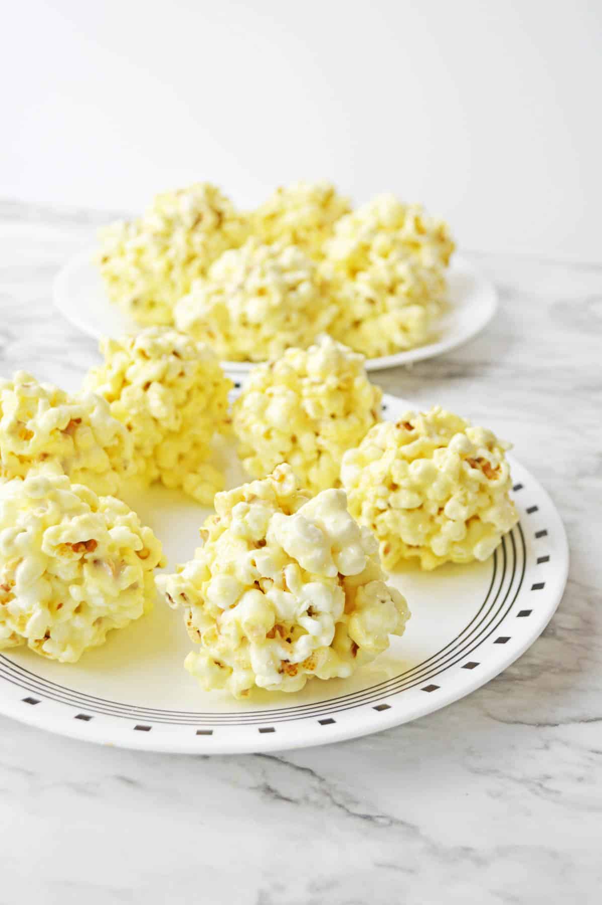 Popcorn balls on a plate on a marble table.