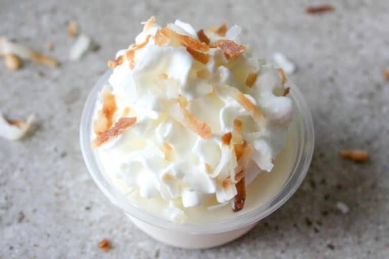 A cup with whipped cream and coconut on it.