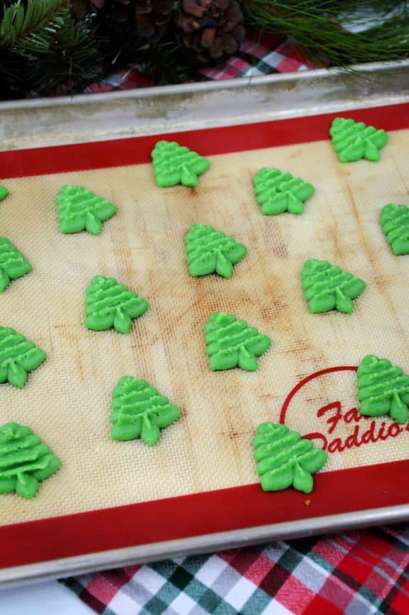 Christmas tree cookies on a baking sheet.