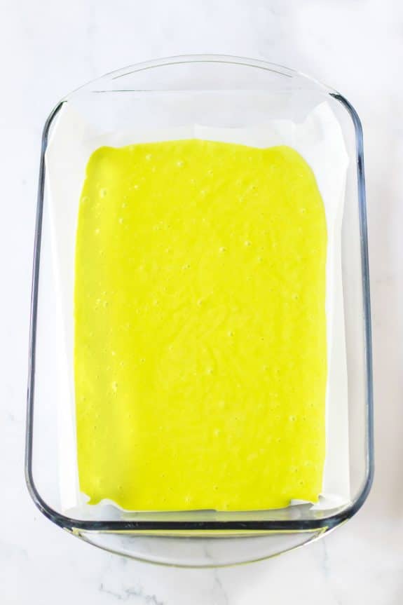 A square of green batter in a glass baking dish.