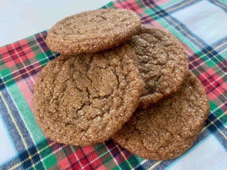 A stack of ginger cookies on a plaid towel.