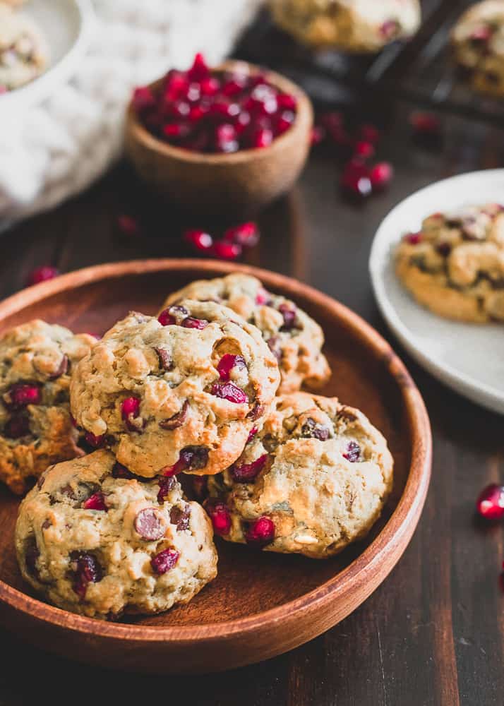Pomegranate chocolate chip cookies on a wooden plate.