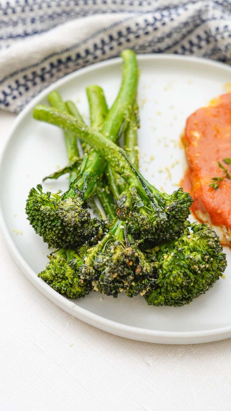 A plate with a piece of fish and broccoli.