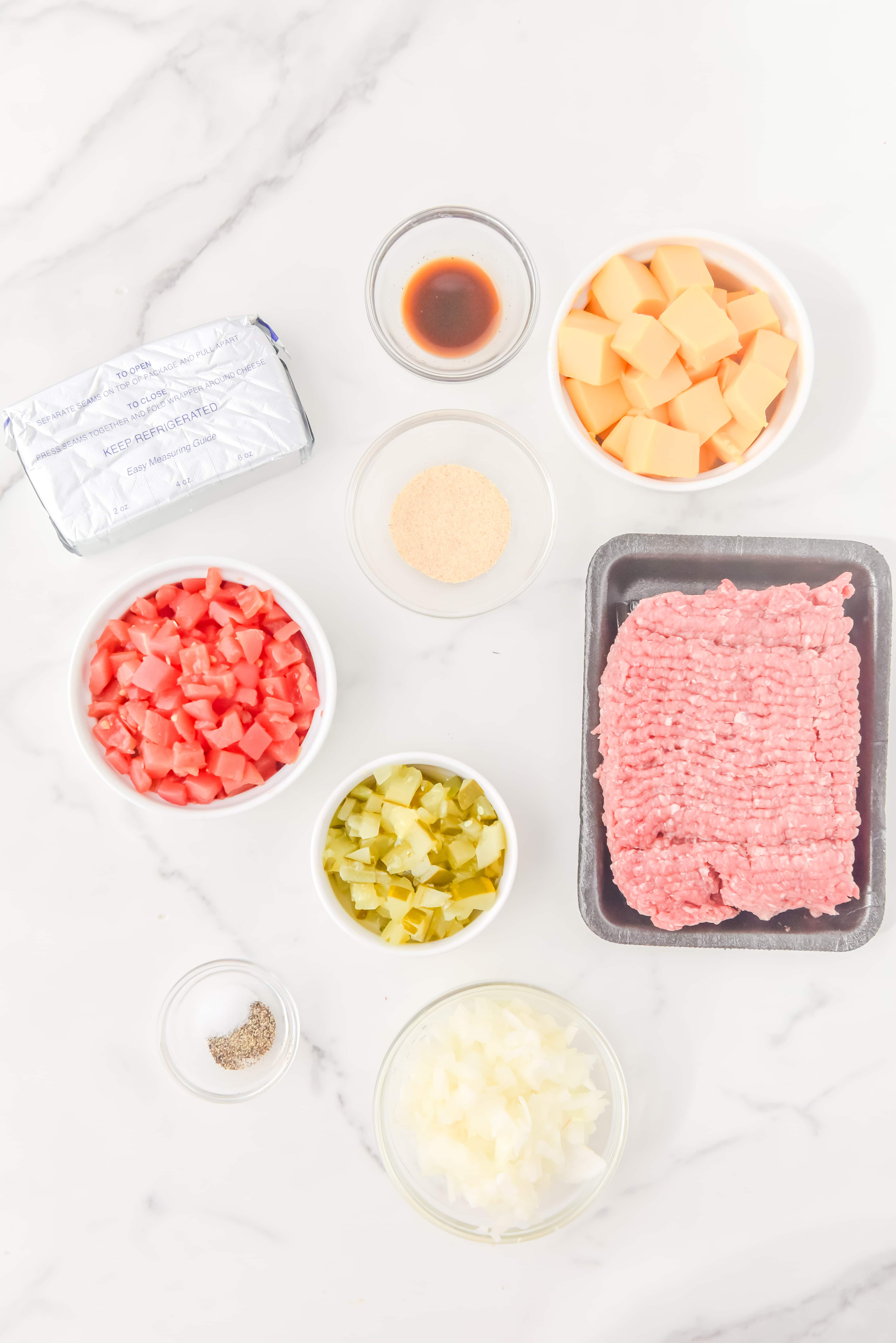 Ingredients for cheeseburger dip on a marble counter