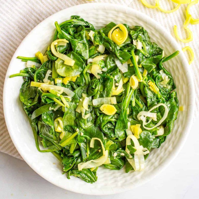 Spinach and lemon salad in a white bowl.