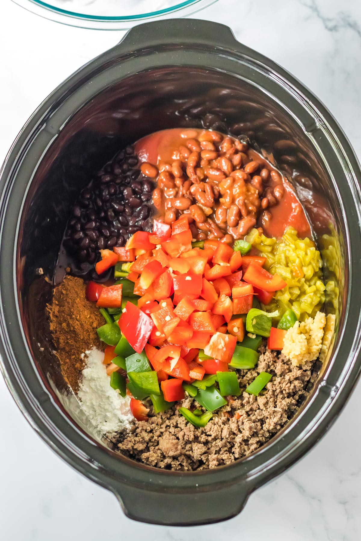 A crock pot full of ingredients for Slow Cooker Frito Casserole
