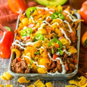 A tray of Slow Cooker Frito Casserole with ingredients on the side.