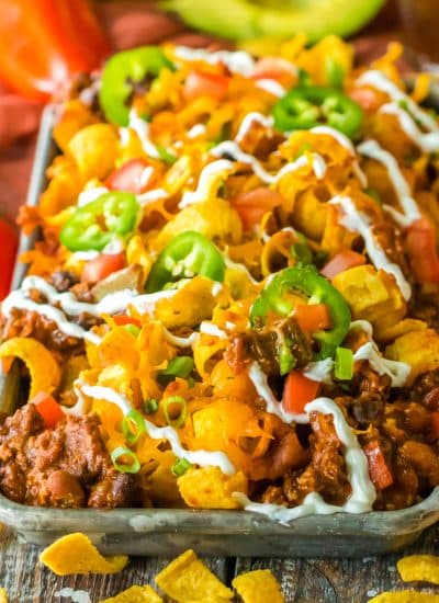 A tray of Slow Cooker Frito Casserole with ingredients on the side.