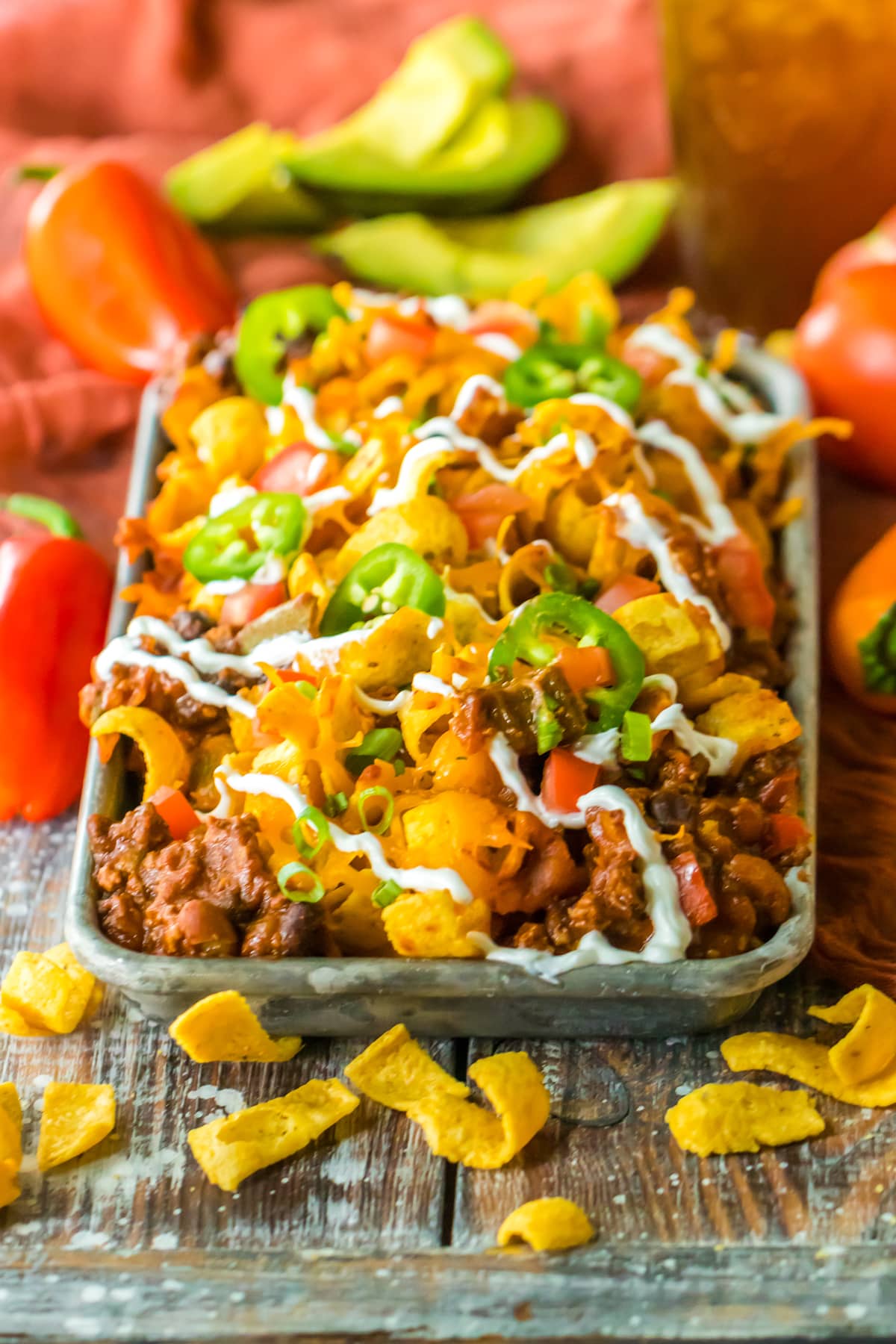 A tray of Slow Cooker Frito Casserole with cheese and other toppings.