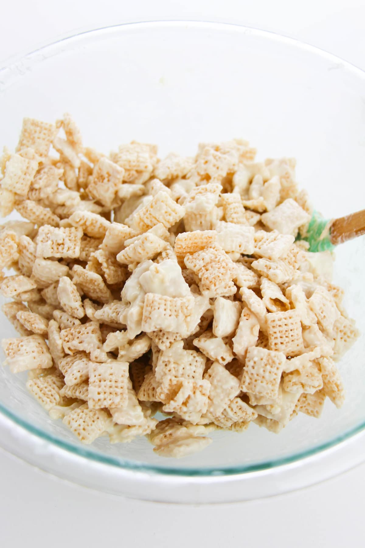 A bowl filled with chex cereal and melted white chocolate