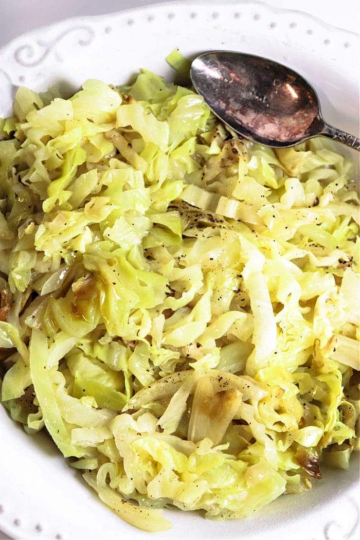 Cabbage in a white plate with a spoon.