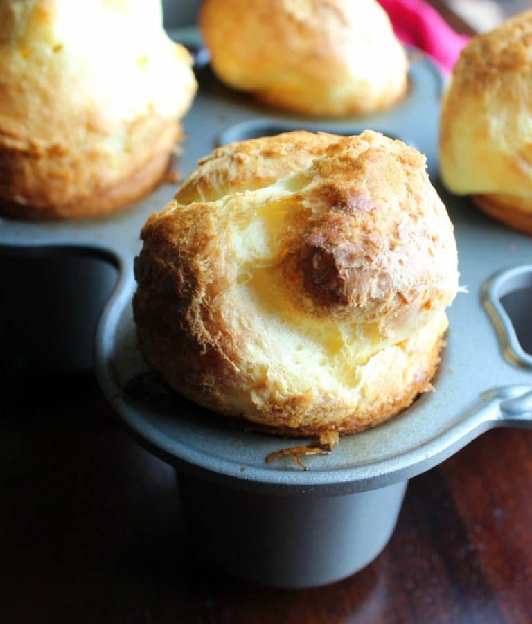 pop overs in a muffin tin on a table.