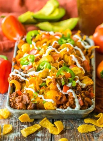 Taco nachos in a baking dish on a wooden table.