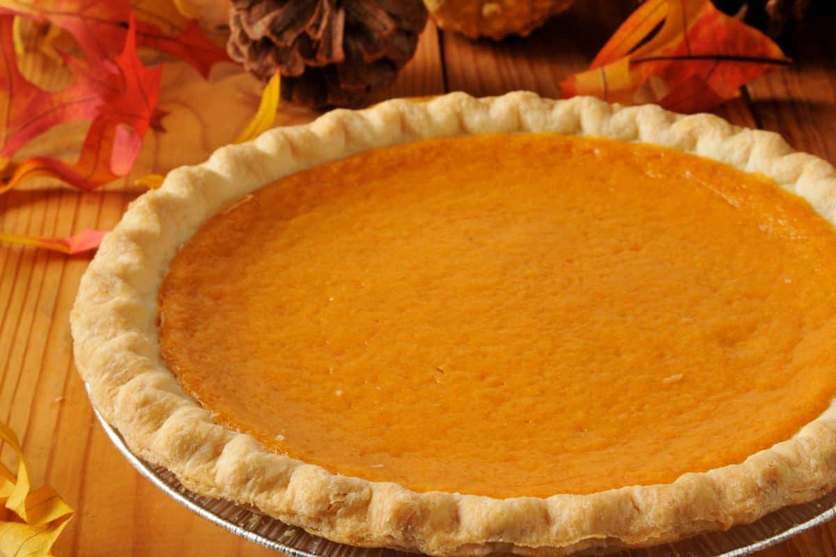 A pumpkin pie sitting on top of a table, perfectly done.