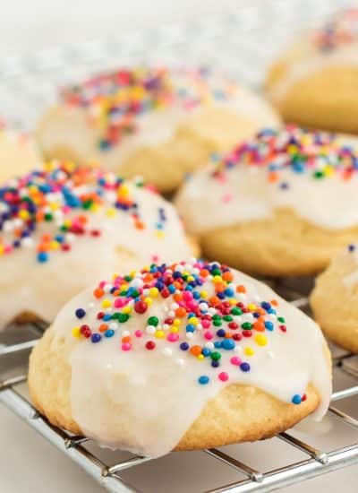 Cookies with icing and sprinkles on a cooling rack.