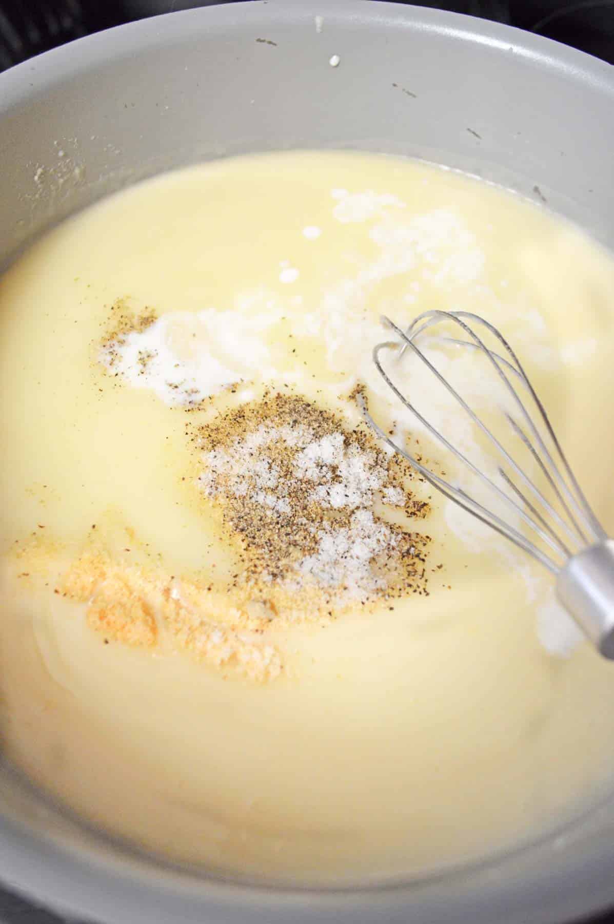 milk mixture with seasonings in bowl with whisk