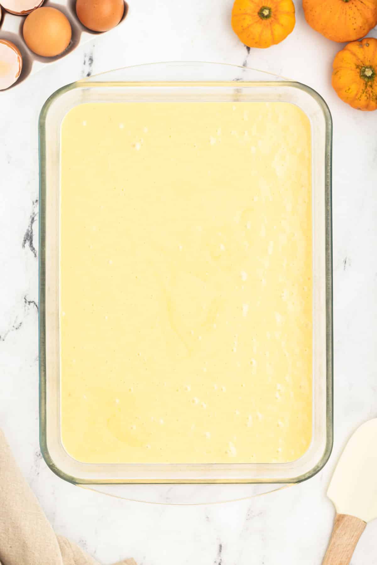 A baking dish with yellow cake batter in it