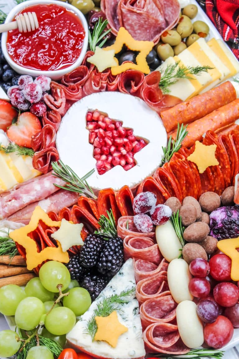 A platter with a variety of meats and cheeses on it.