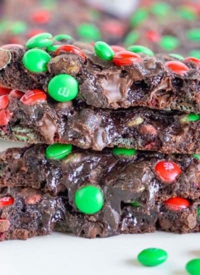 A stack of chocolate M&M Christmas cookies with green and red sprinkles.