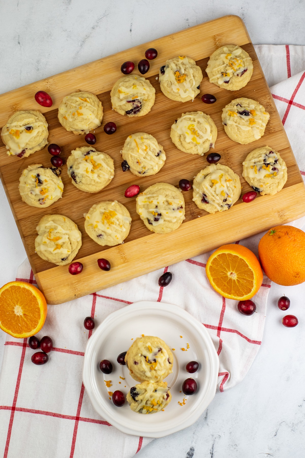 Cranberry orange cookies on a cutting board and others on a white plate