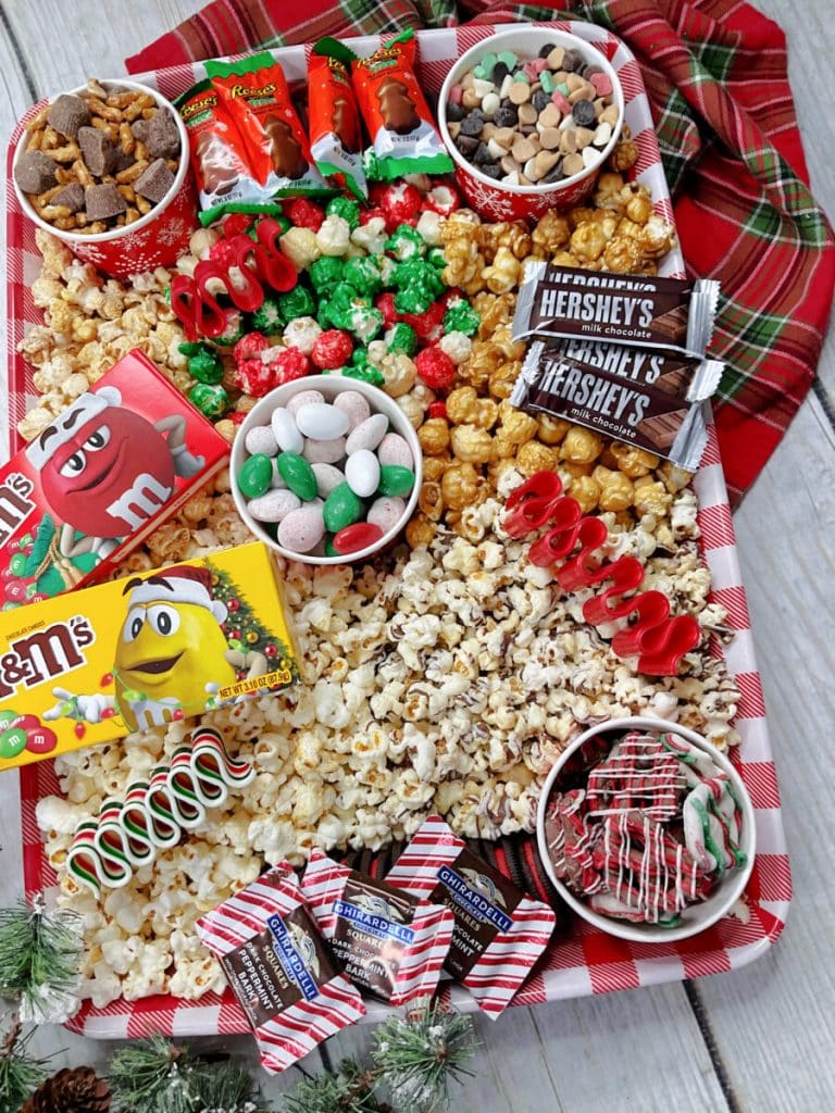 A tray full of popcorn, candy, and candy canes.