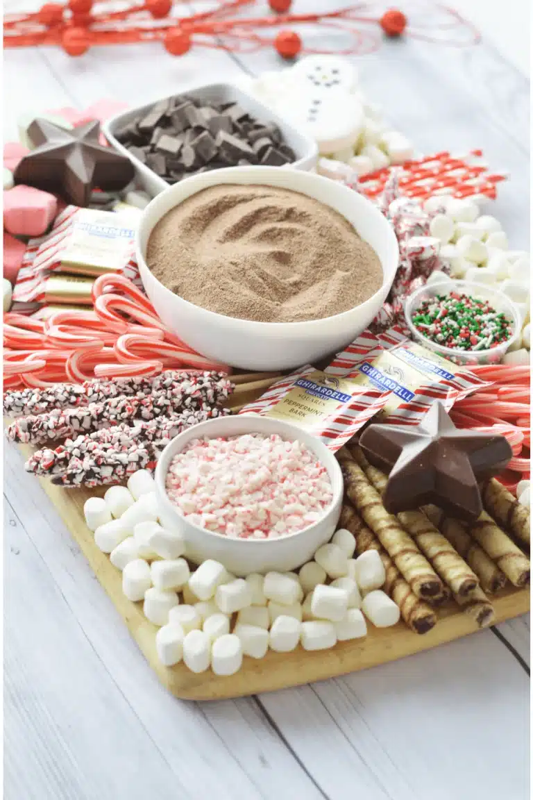 A christmas dessert tray with candy canes, marshmallows, and powdered sugar.