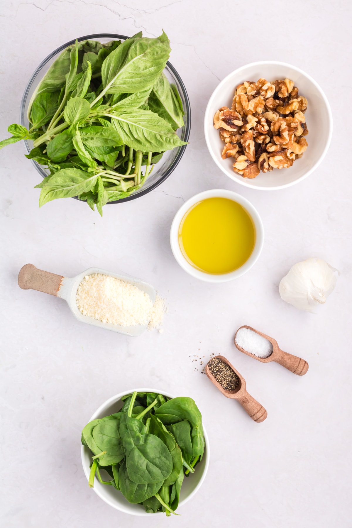 Ingredients for a spinach homemade pesto recipe on a white background.
