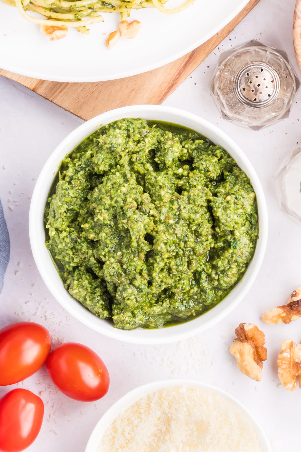 A bowl of pesto with tomatoes, basil, and other ingredients.