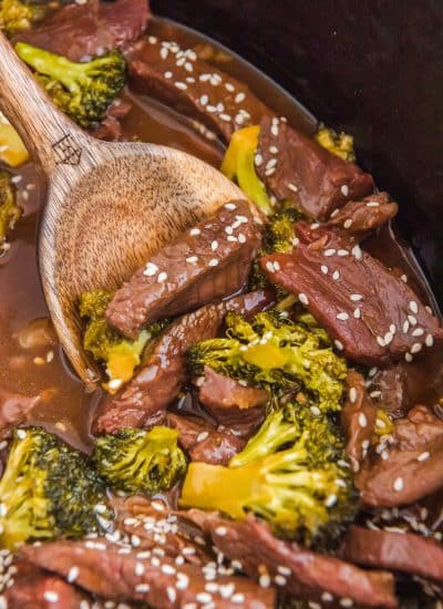 Slow Cooker Beef and Broccoli in a pot with a wooden spoon.