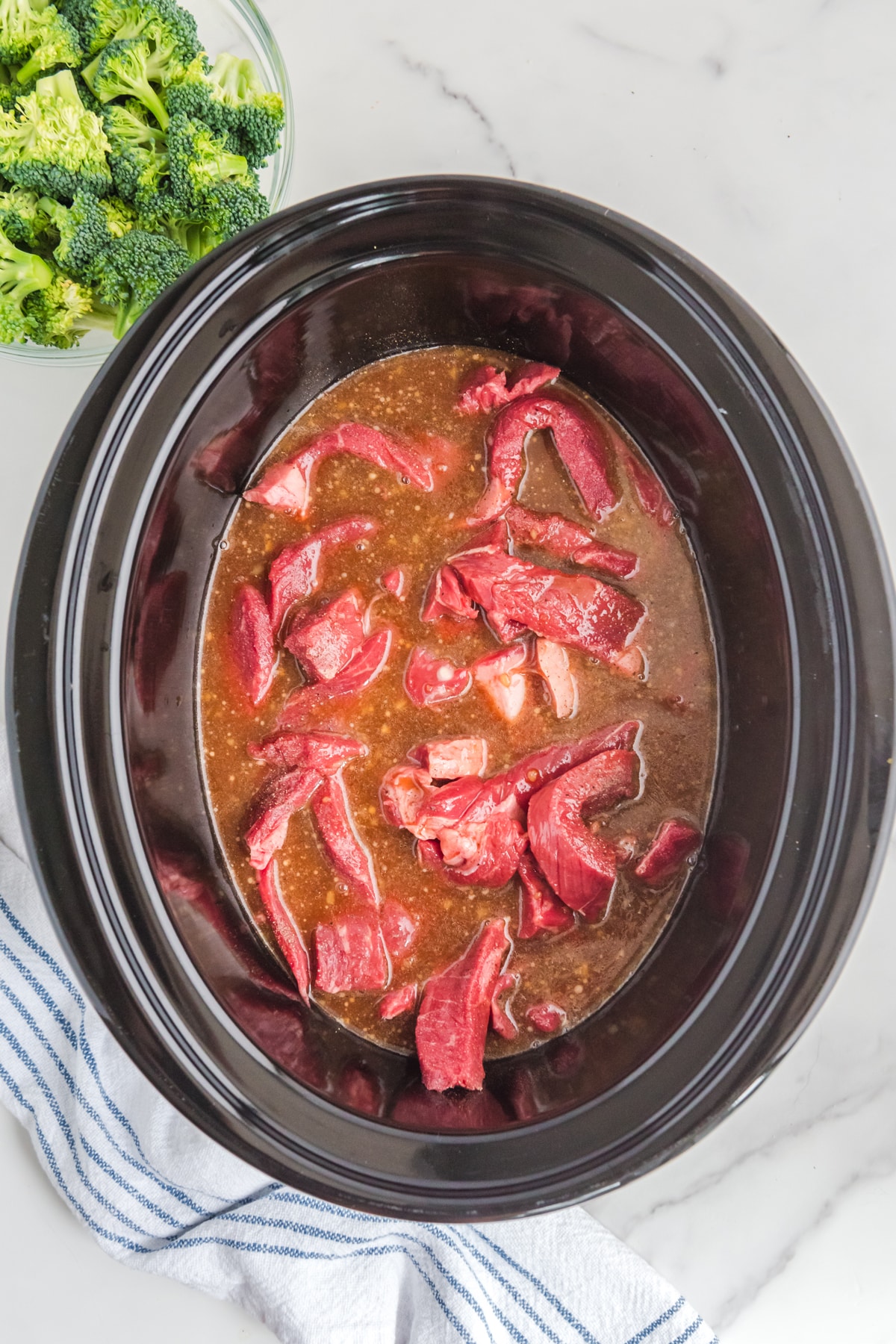A crock pot full of beef and broccoli.