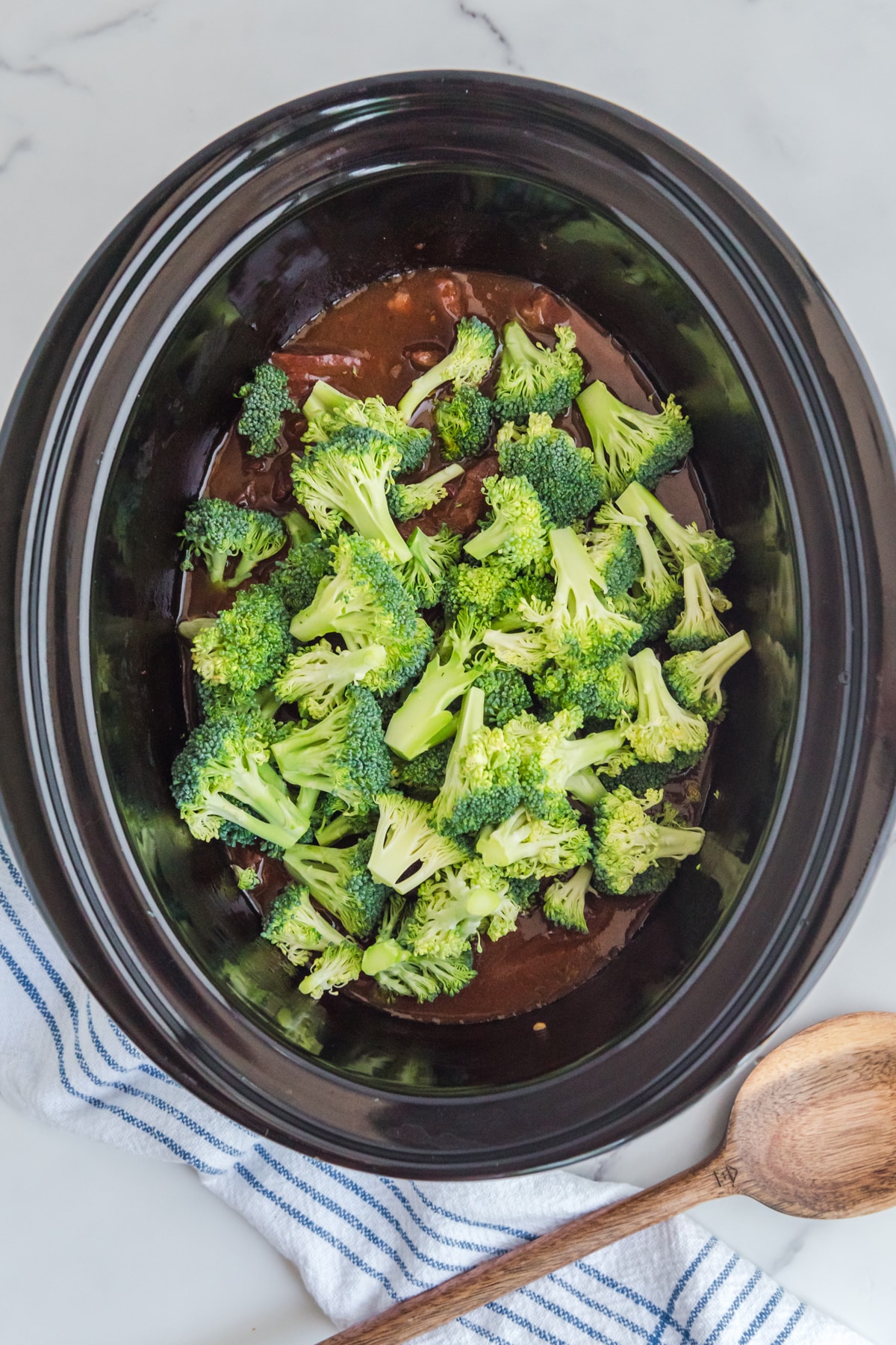 A bowl of broccoli in a slow cooker.
