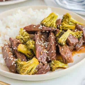 Slow Cooker Beef and Broccoli stir fry on a white plate.