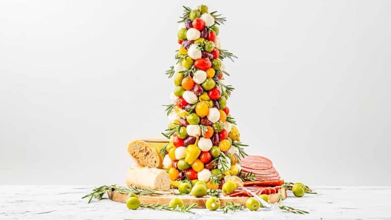 A tower of cheese and olives on a table.