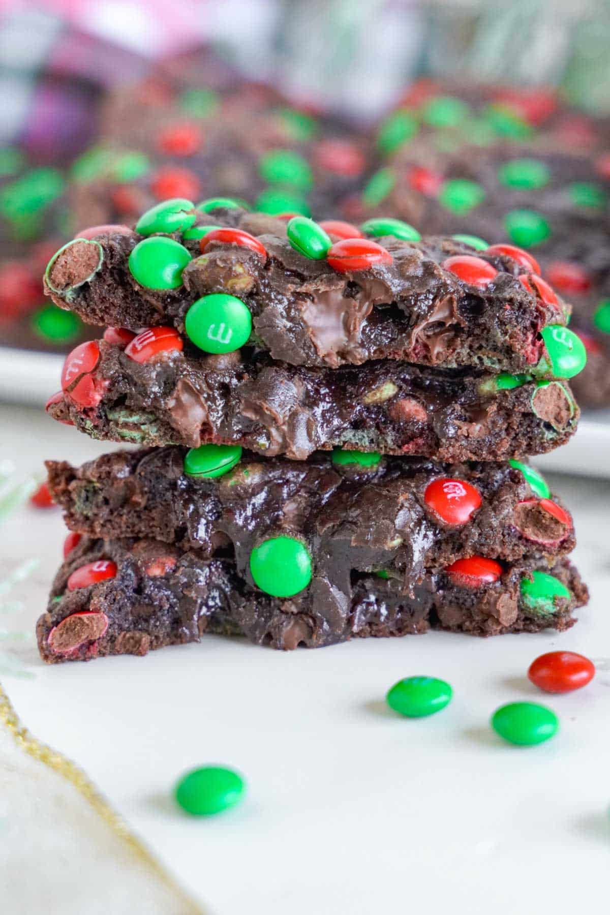 A stack of chocolate m&m cookies with green and red sprinkles.