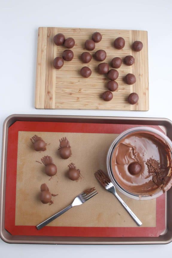 A tray with chocolate balls and a fork on it.