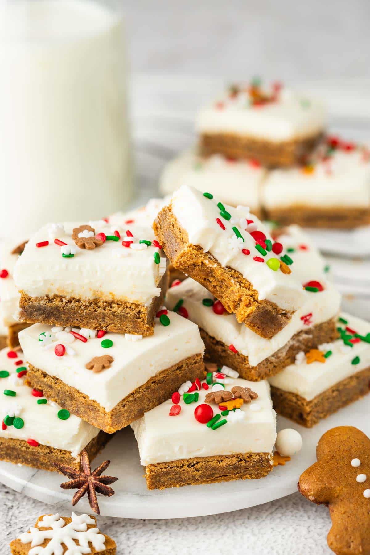 Gingerbread cookie bars on a plate with a glass of milk.