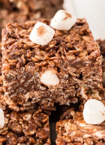 A stack of hot chocolate krispies treats with marshmallows on top.