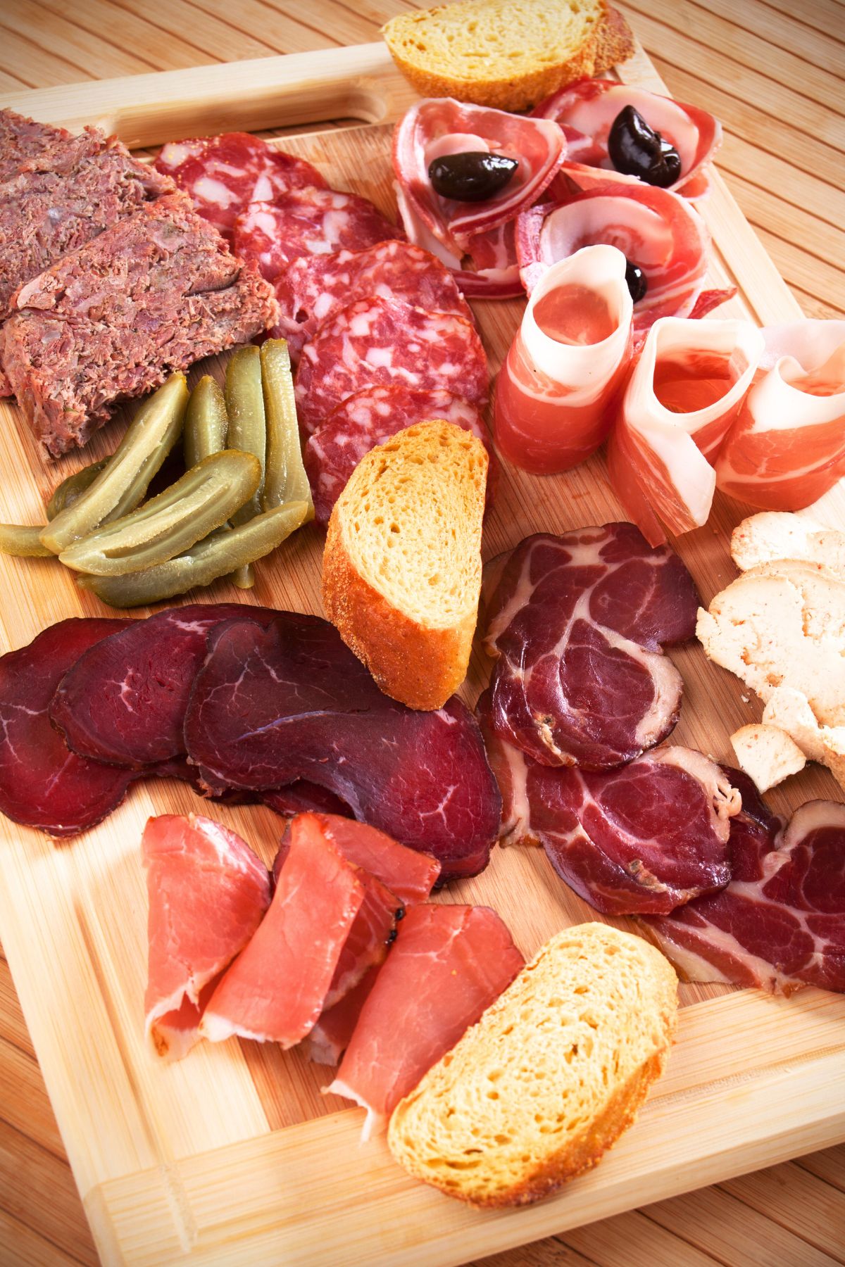 How to build a charcuterie board with a variety of meats on a wooden cutting board.
