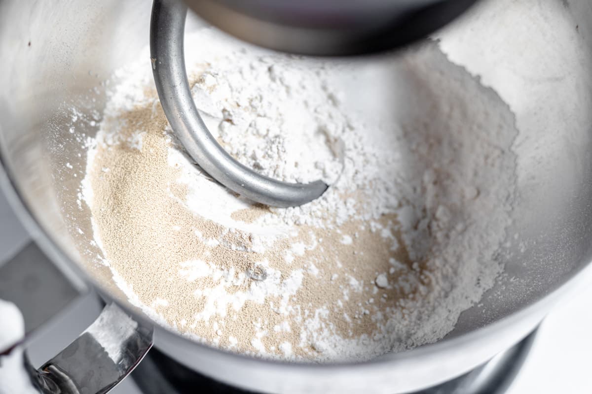 A close up of flour being mixed in a mixer.