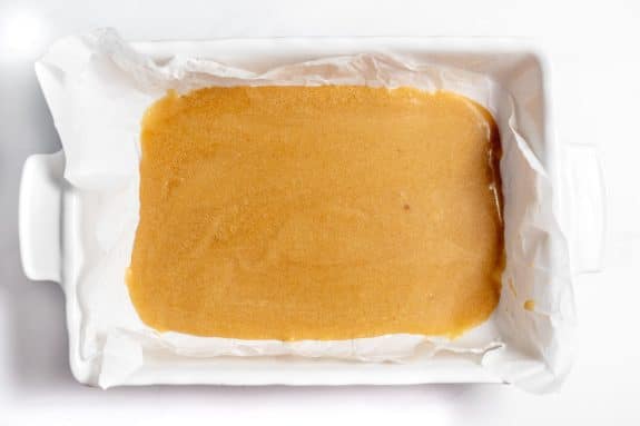 A square of caramel in a white dish.